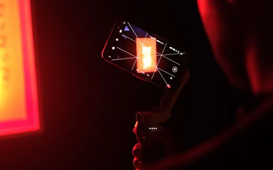 Celular em estabilizador gravando vídeo sob luz vermelha